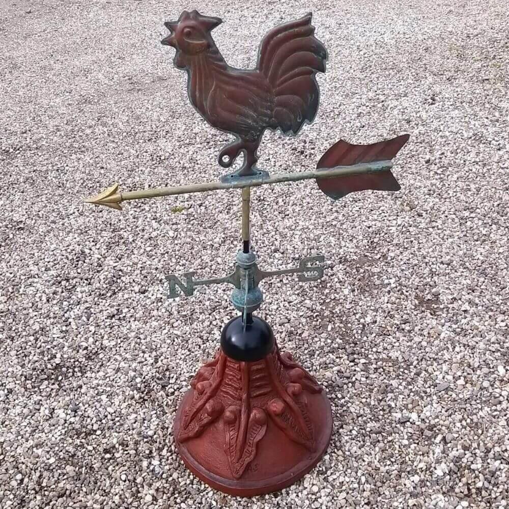 Cockerel weathervane fixed to a round ridge tile base