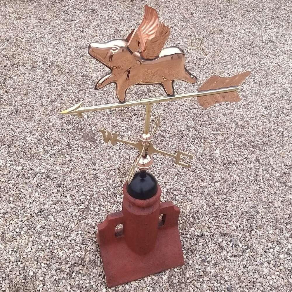 Flying pig copper weathervane on a 90 degree ridge tile finial