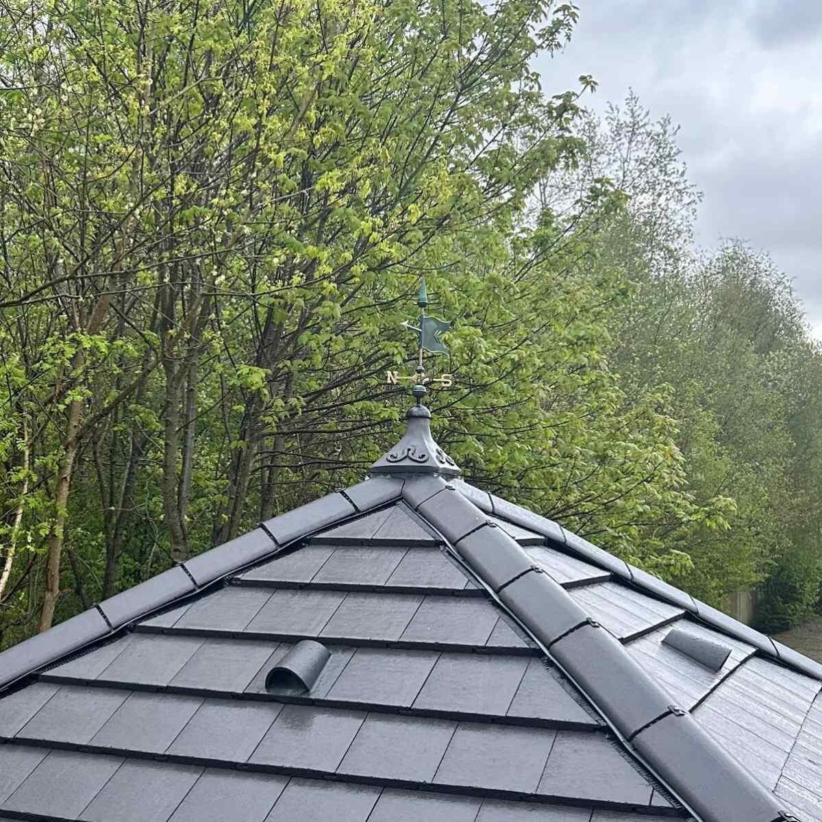 Banner verdigris weathervane fixed to a square ridge tile finial
