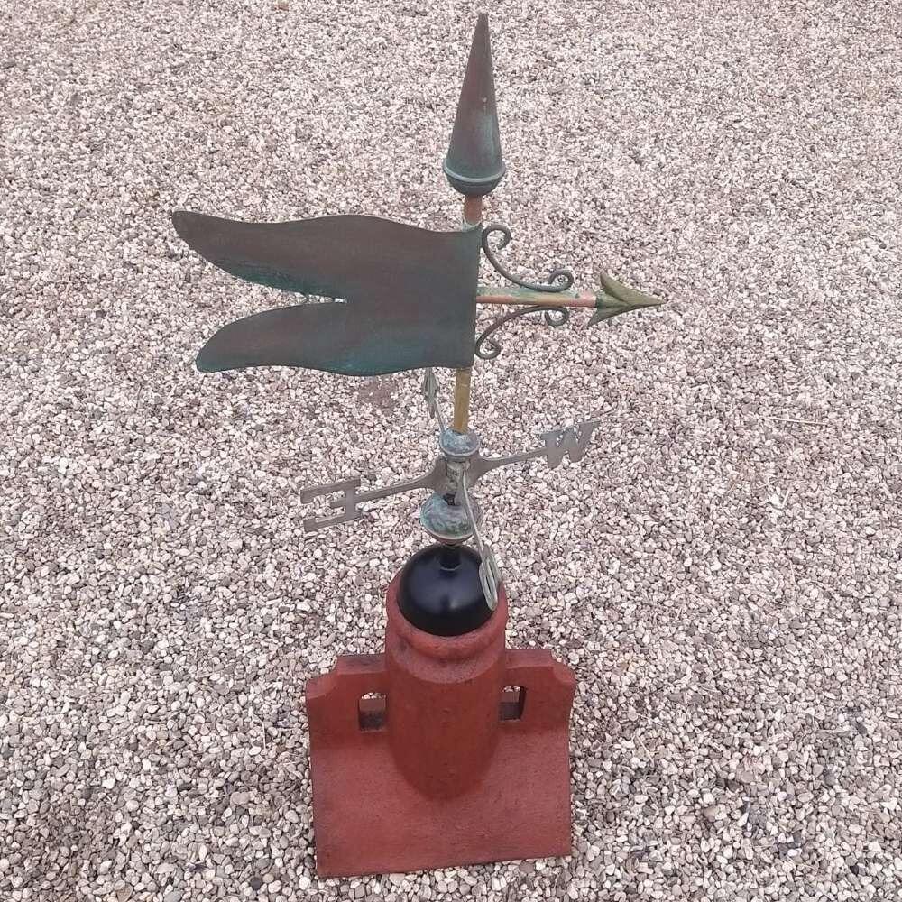 Verdigris banner weathervane fixed on a 45 degree ridge base finial