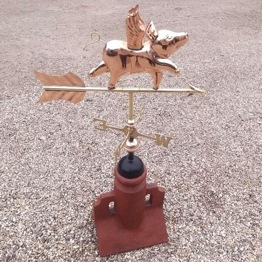 Flying pig copper weathervane on a 90 degree ridge tile finial