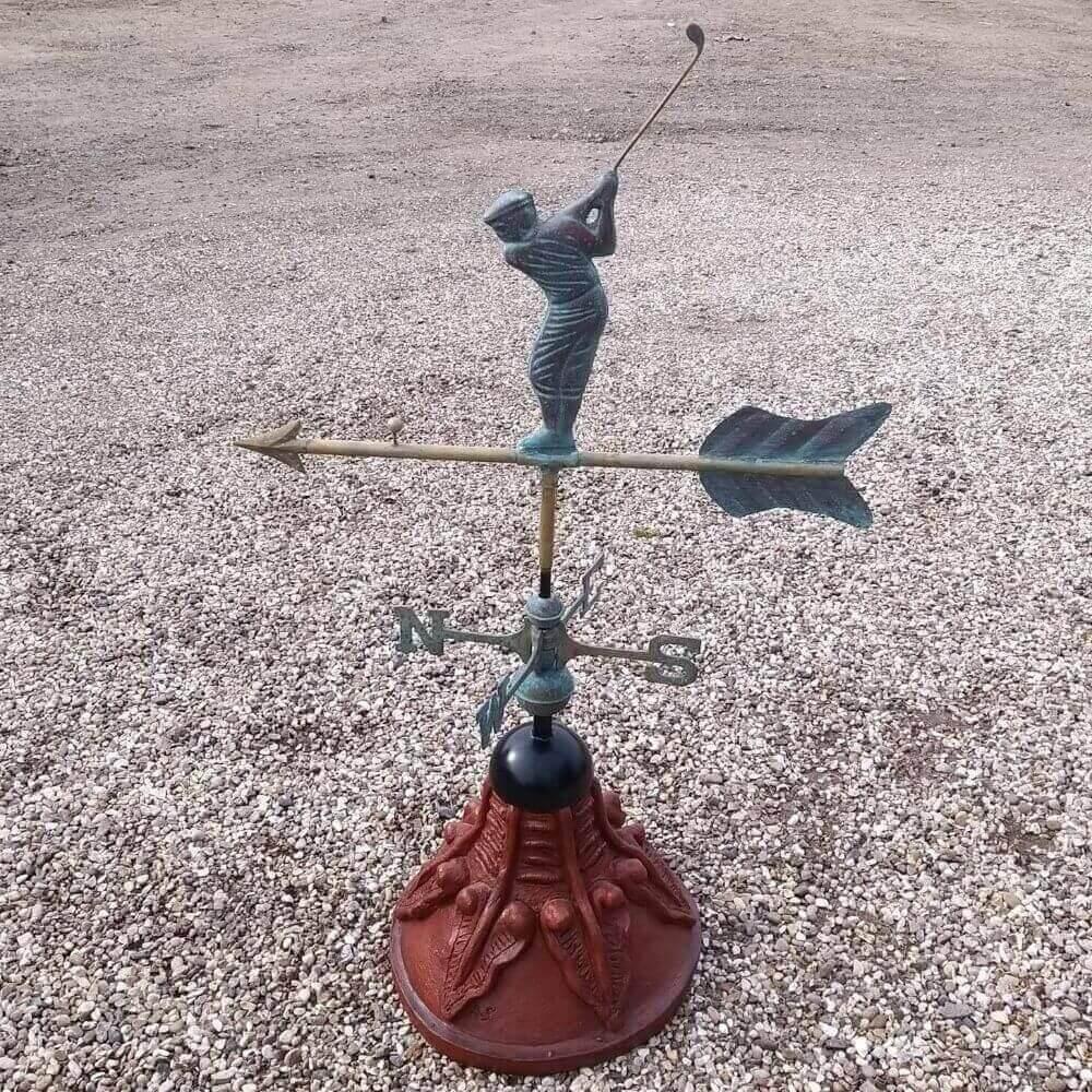 Golfer weathervane fixed to a round ridge tile cap