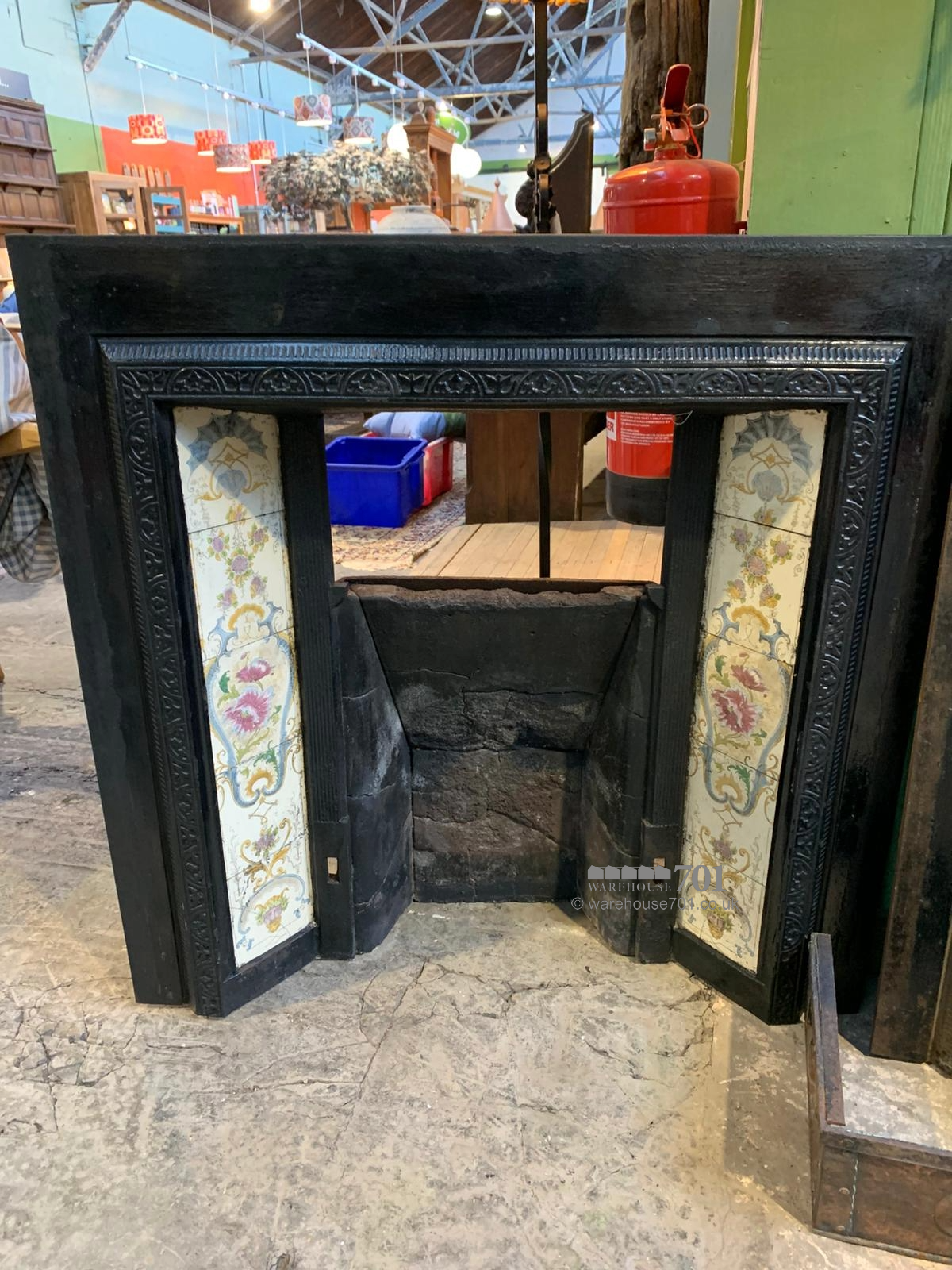 Cast iron fire place with floral tiles