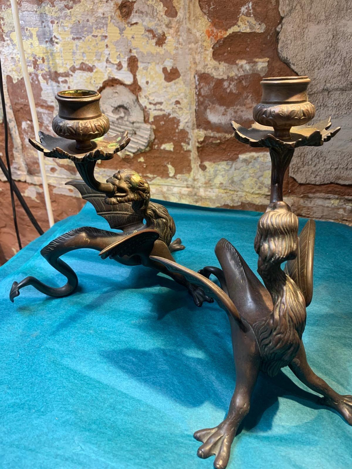 Antique pair of bronze mythical beast candlesticks