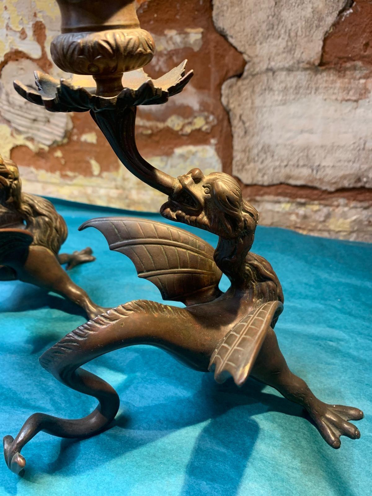 Antique pair of bronze mythical beast candlesticks