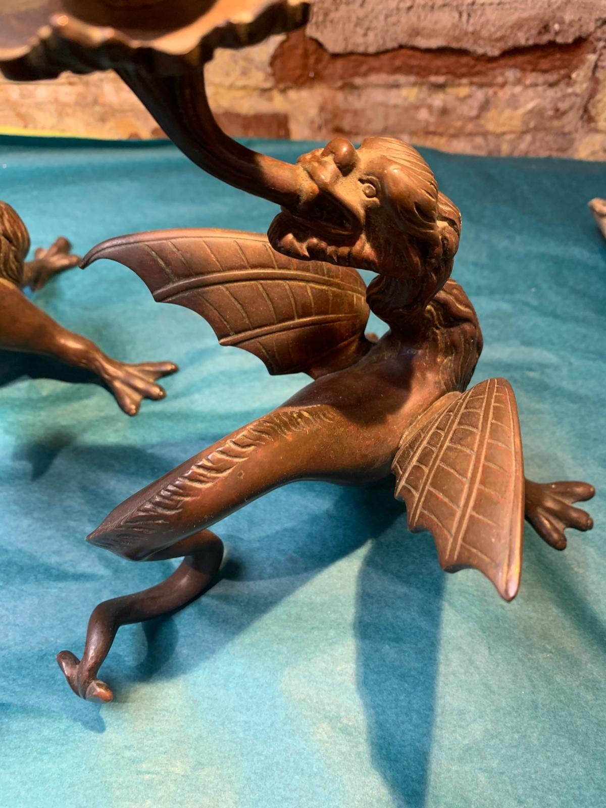 Antique pair of bronze mythical beast candlesticks