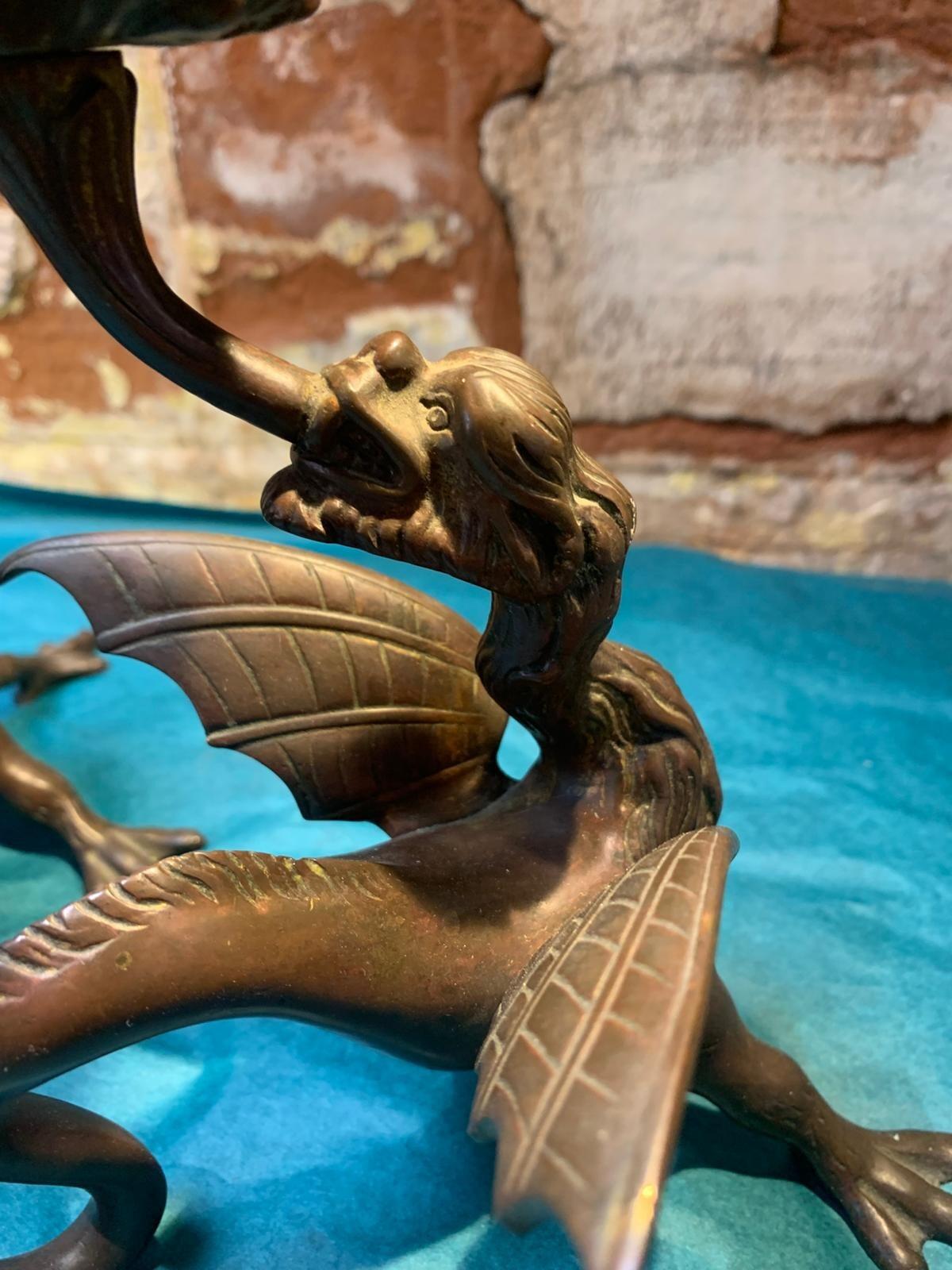 Antique pair of bronze mythical beast candlesticks