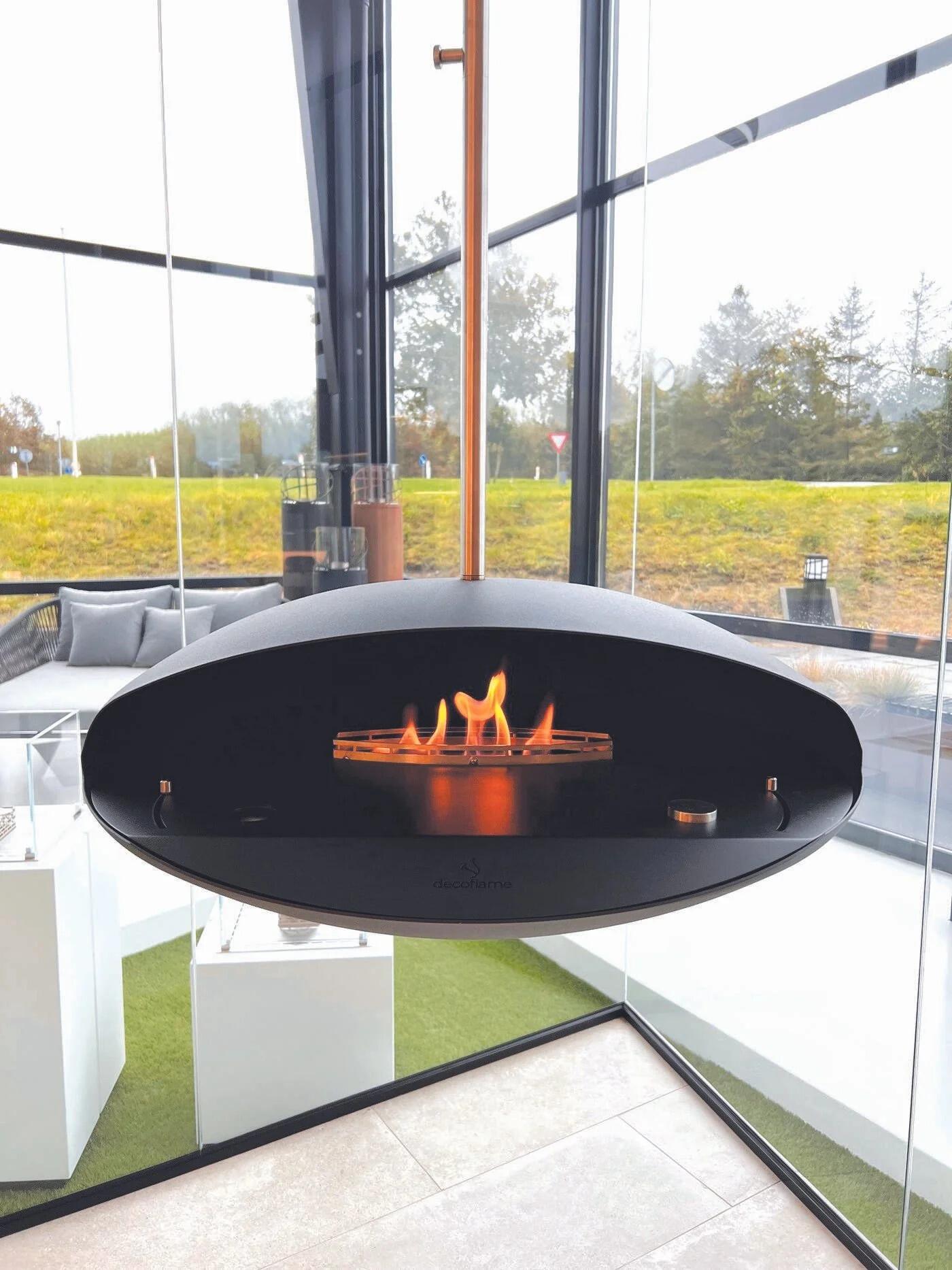 Espoo ceiling-hung fire bowl with flames in a glazed room