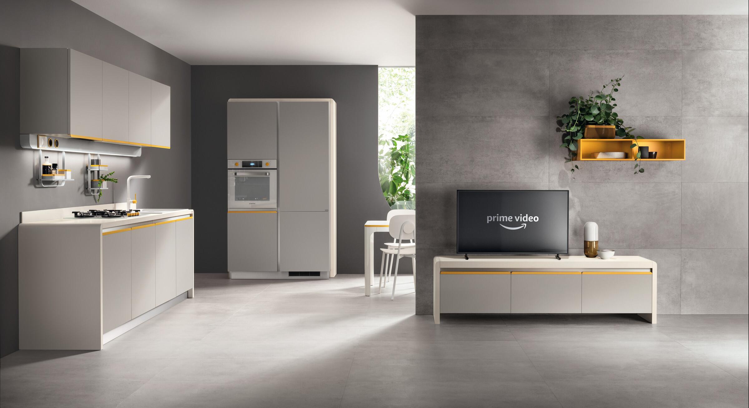 Scavolini Dandy Plus kitchen in pale grey with a yellow wall shelf and living area