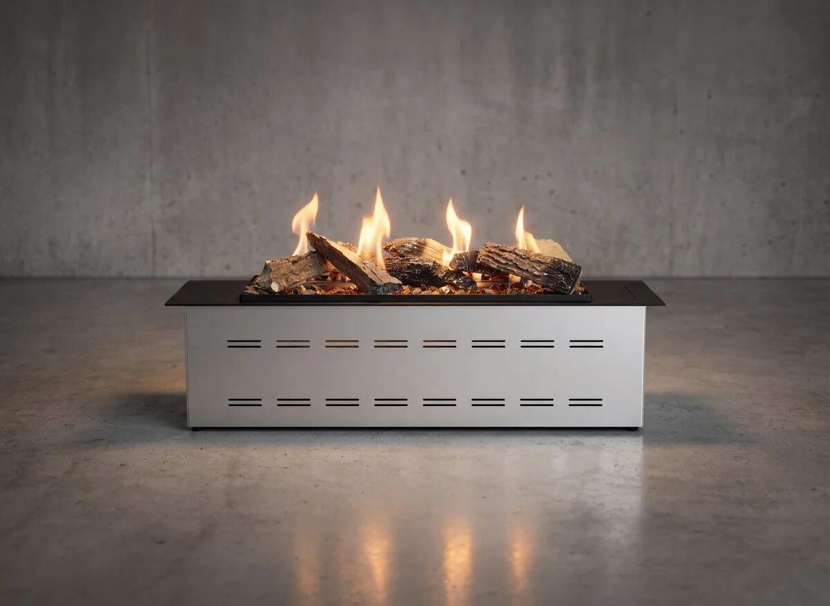 LogicWood Linear burner lit with ceramic logs and flames on a dark studio floor