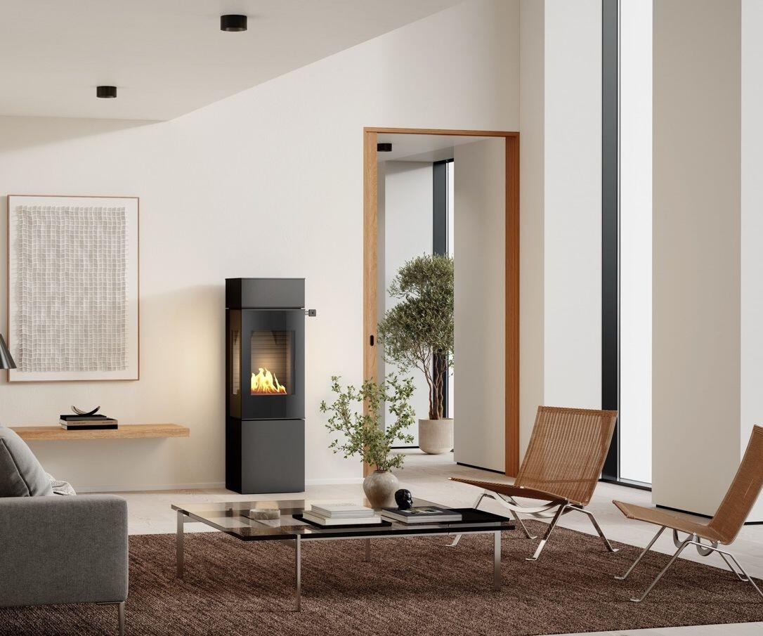 Rais Nexo 140 Bio stove with a glass coffee table and leather lounge chairs