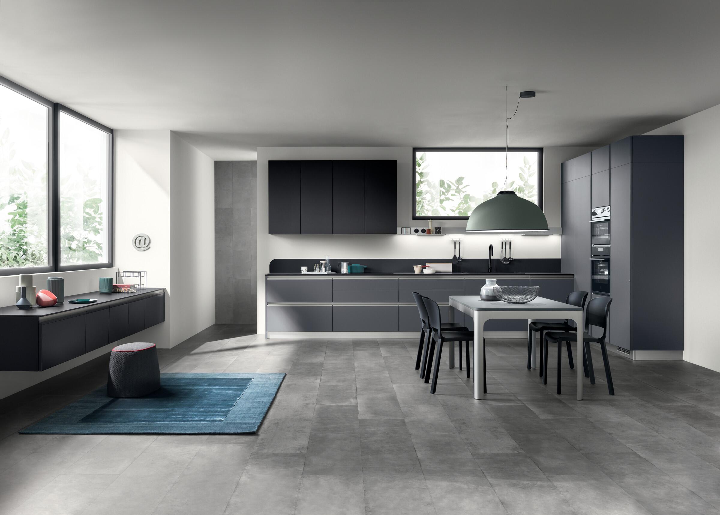 Scavolini Dandy Plus kitchen in dark tones with a dining table in an open-plan room
