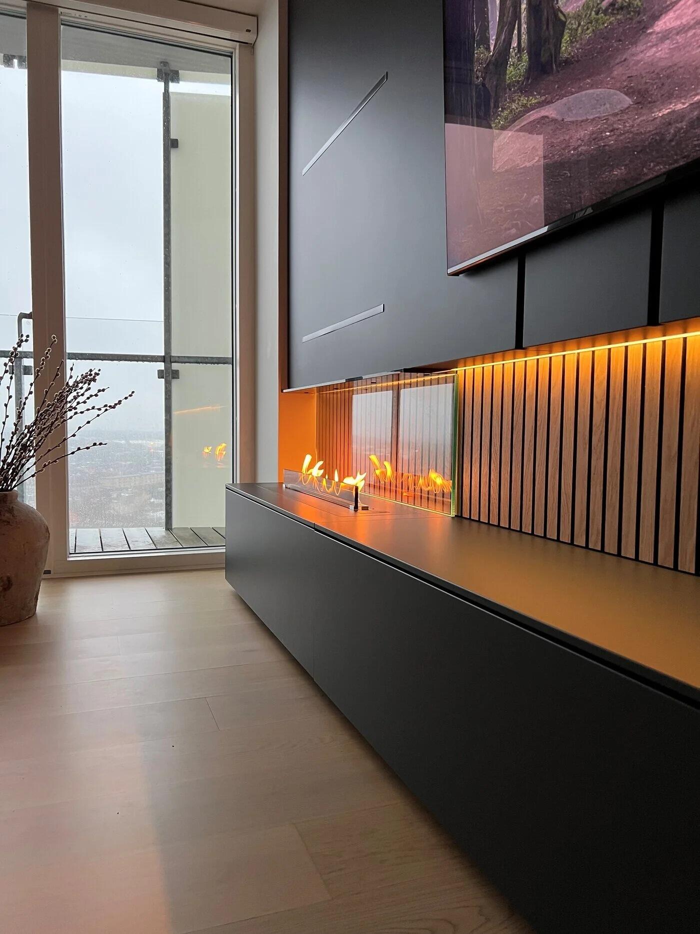 Denver F6 burner in a black media wall with warm LED lighting and a television above