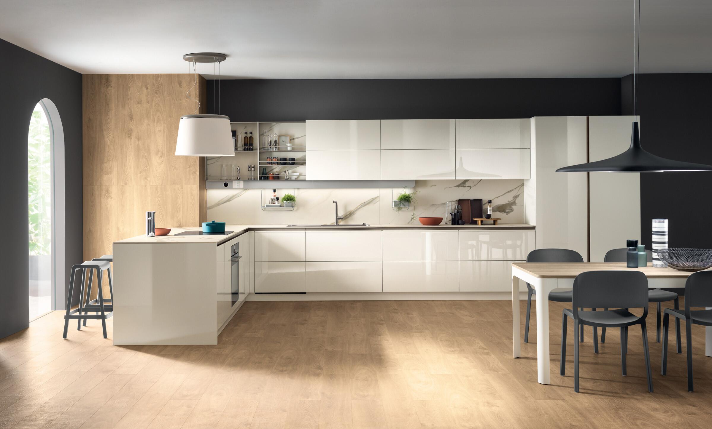 Scavolini Dandy Plus L-shaped kitchen in white with a dining table and pendant hood