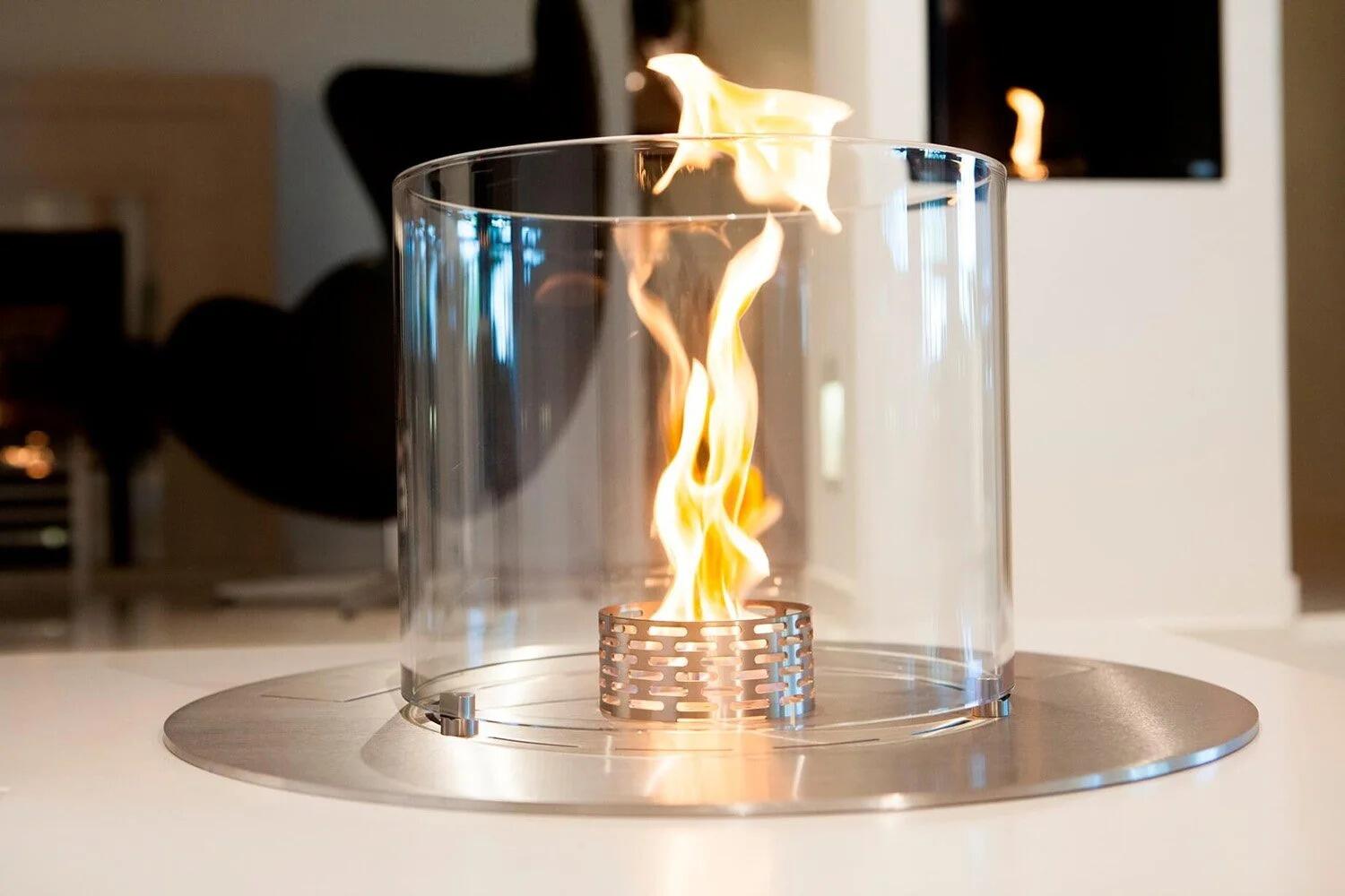 Close-up of the Denver Round flame inside its glass cylinder on a stainless steel plate