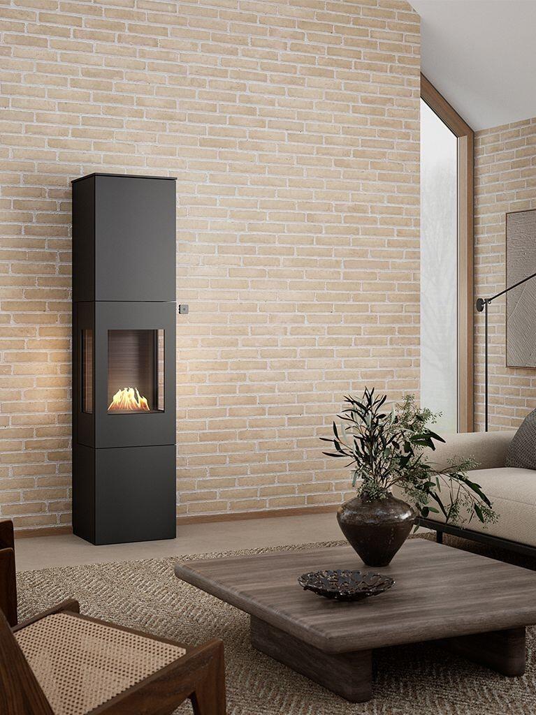 Rais Nexo 185 Bio tall bioethanol stove in black against a pale brick wall