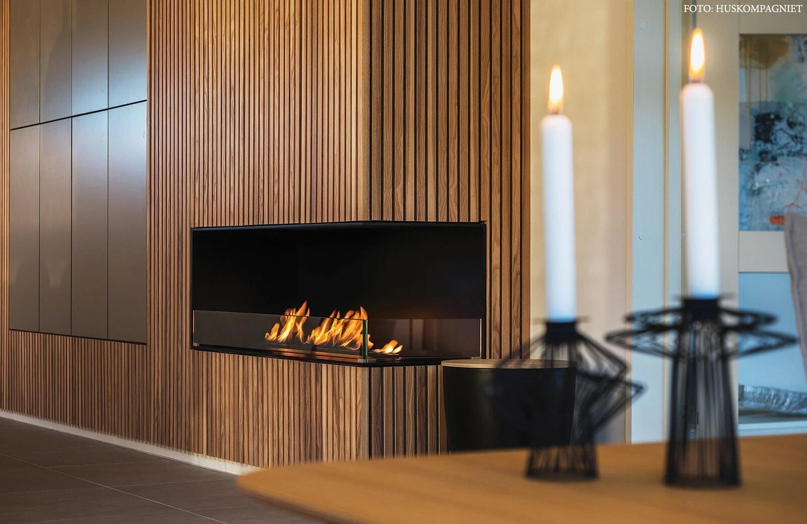 Montreal corner fire in dark wood panelling with tall white candles in front