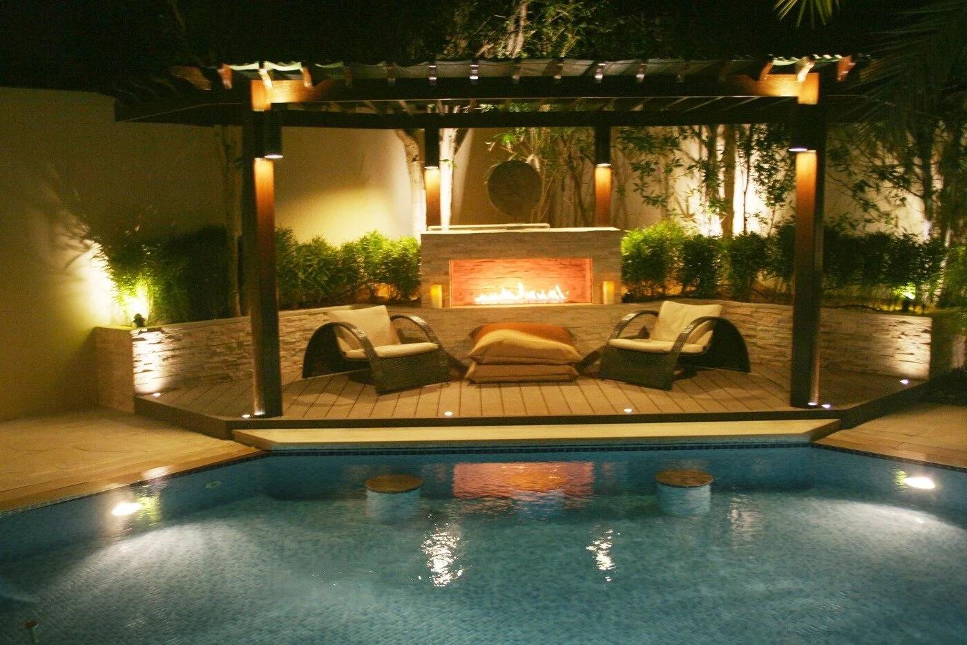 Outdoor built-in burner in a poolside pergola at night