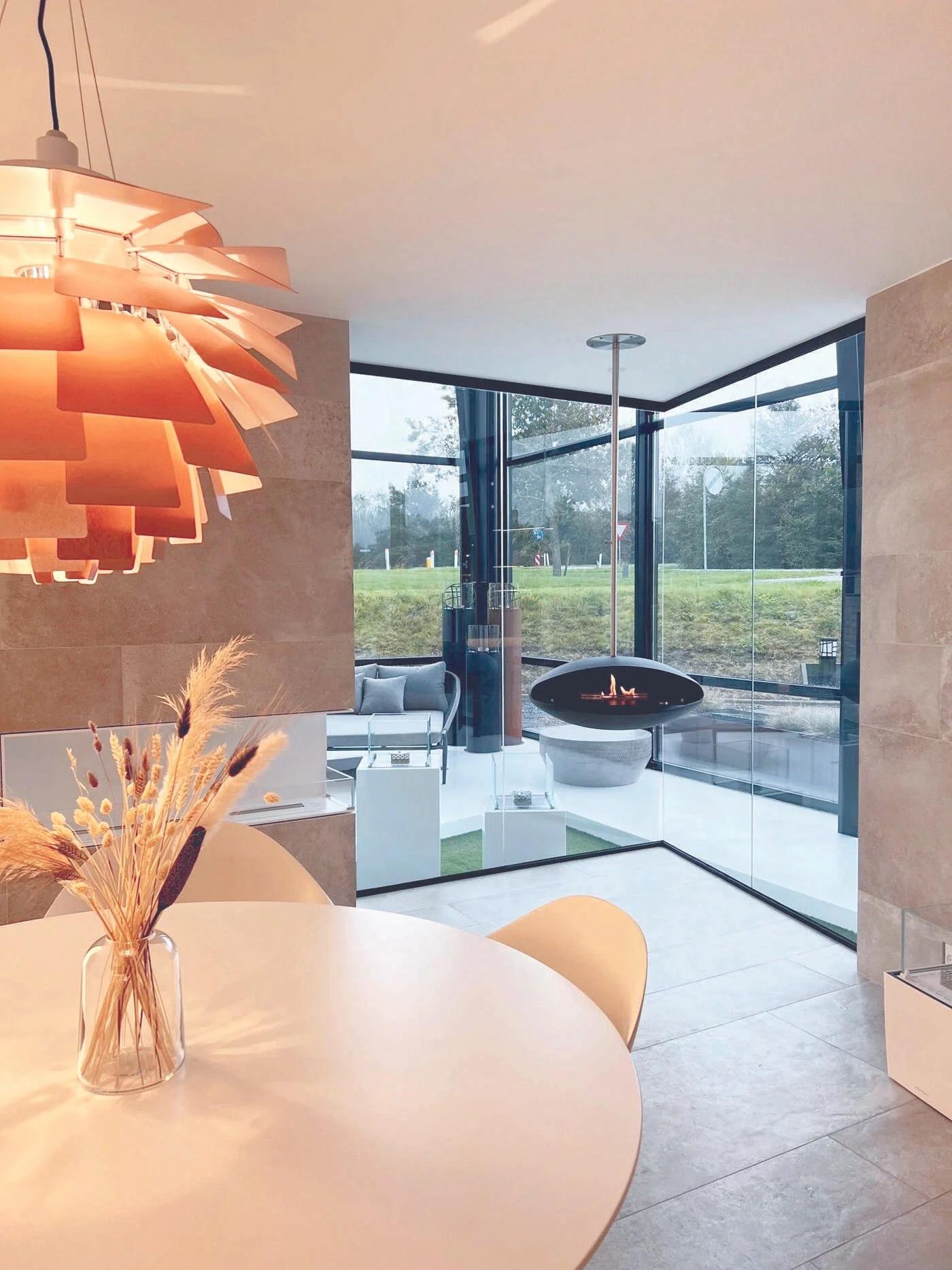 Espoo hanging fire seen past a dining table with an orange pendant light