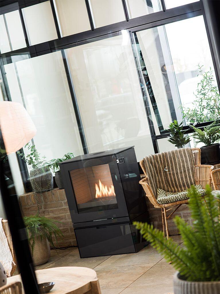 Rais Q-Tee 2 Bio bioethanol stove in black on its base in a conservatory