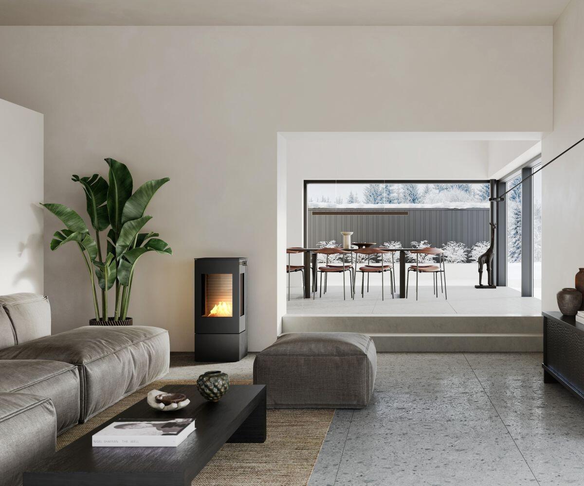 Rais Nexo 100 Bio freestanding bio stove beside a sofa with a dining area behind