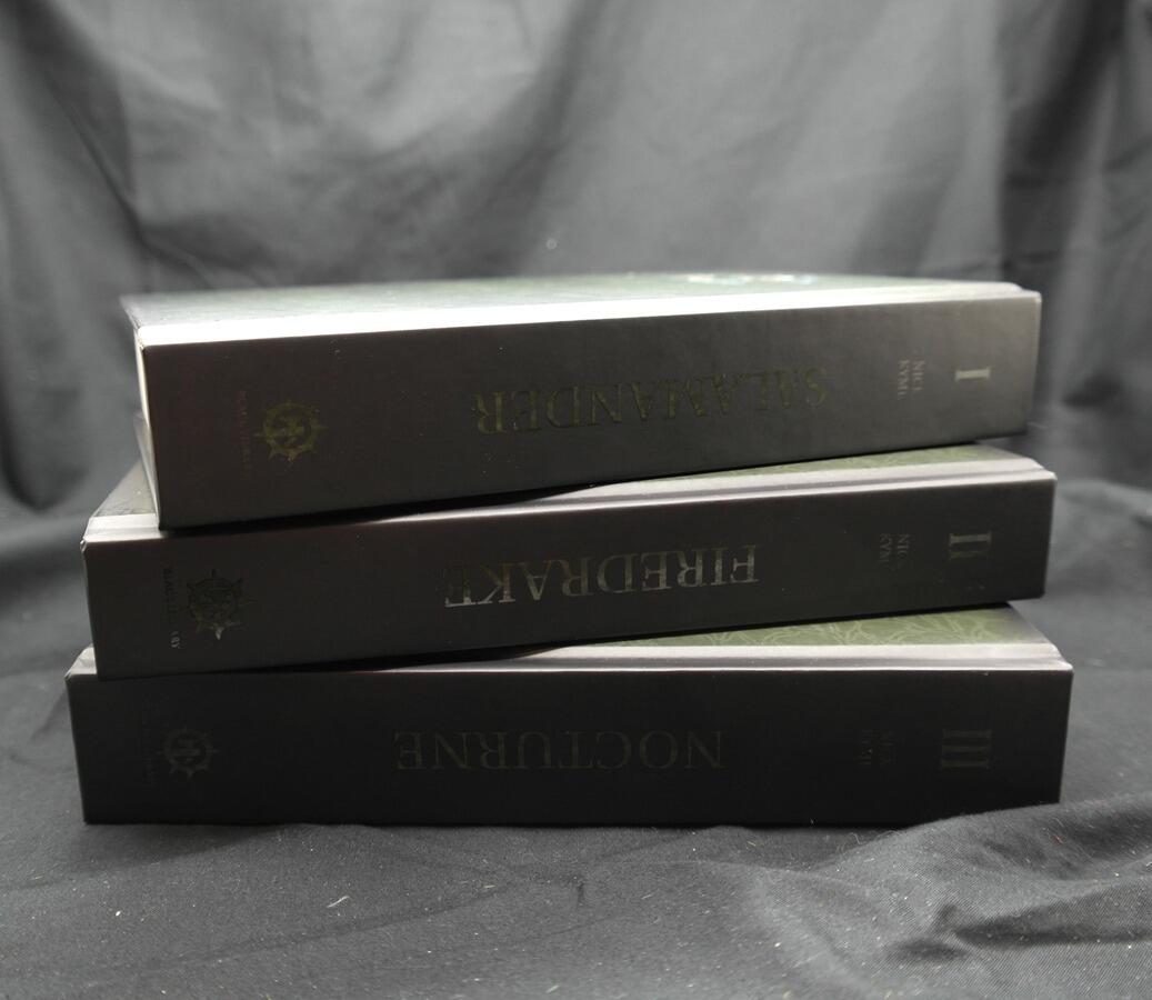 Three foiled hardbacks – spines aligned