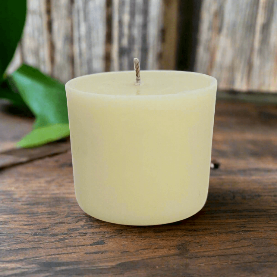 White essential oil candle refill on a wooden surface with a blurred natural background
