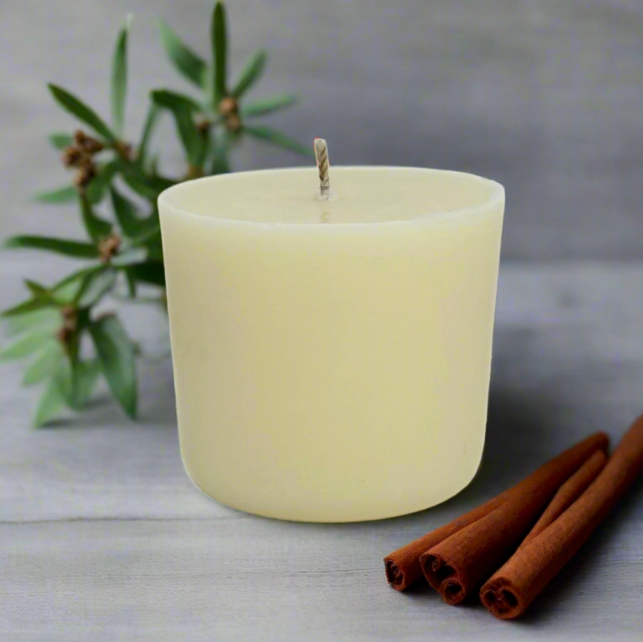 White refill candle with cinnamon sticks, lavender and Ylang Ylang on a light surface