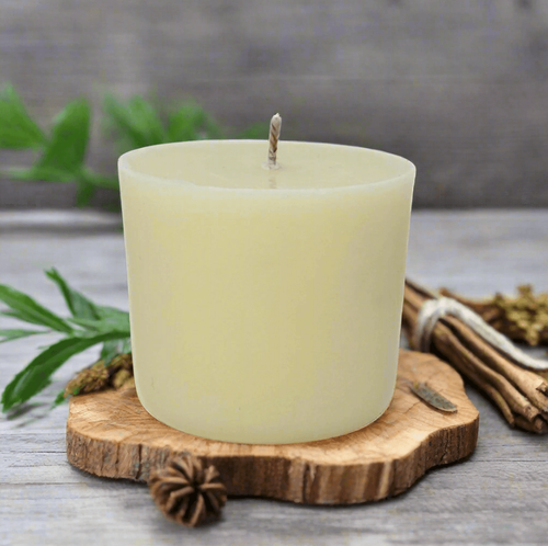 White candle refill on a wooden coaster with Geranium, Pine and Ylang Ylang in the background