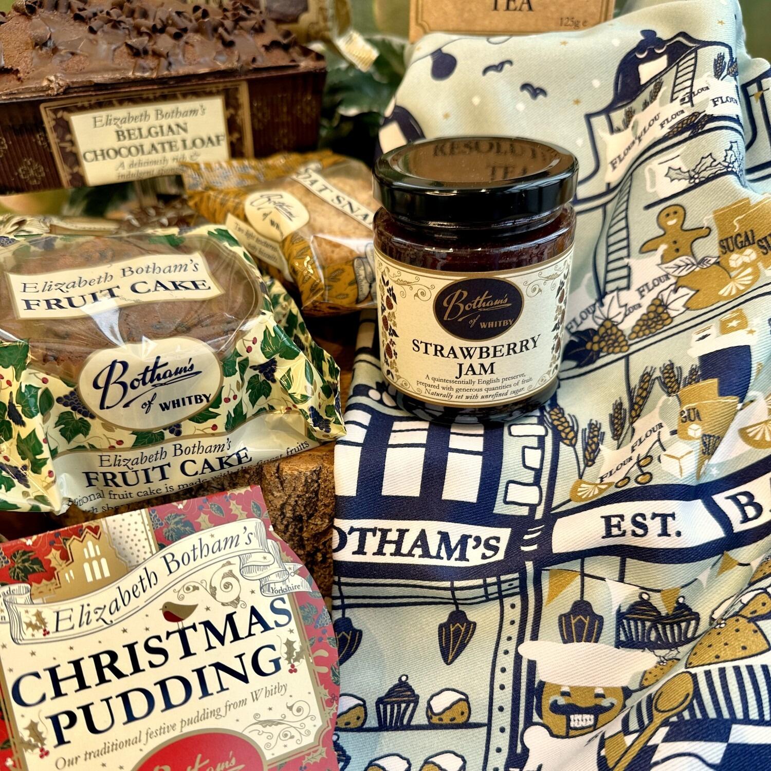 ‘Season’s Greetings Gift Box’ festive food hamper is a delightful Christmas hamper containing delicious bakes from Botham's of Whitby bakery, with a focus on Elizabeth Botham’s Fruit Cake, Christmas Pudding, Belgian Chocolate Loaf and jar of Strawberry Jam. Add some Botham’s magic to washing up with the festive tea towel by family designer, Anita Marshall, and this year’s design depicts a magical interpretation of a Botham’s Nutcracker scene. This is an exquisite Yorkshire Christmas food hamper by post from Botham’s iconic Whitby bakery.