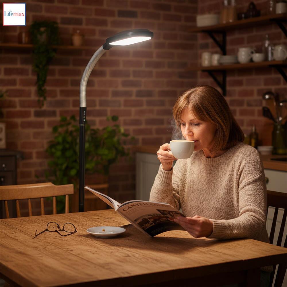 This is an image of the Lifemax Professional Reading Floor Light in black being used by a lady to read a magazine while enjoying a coffee