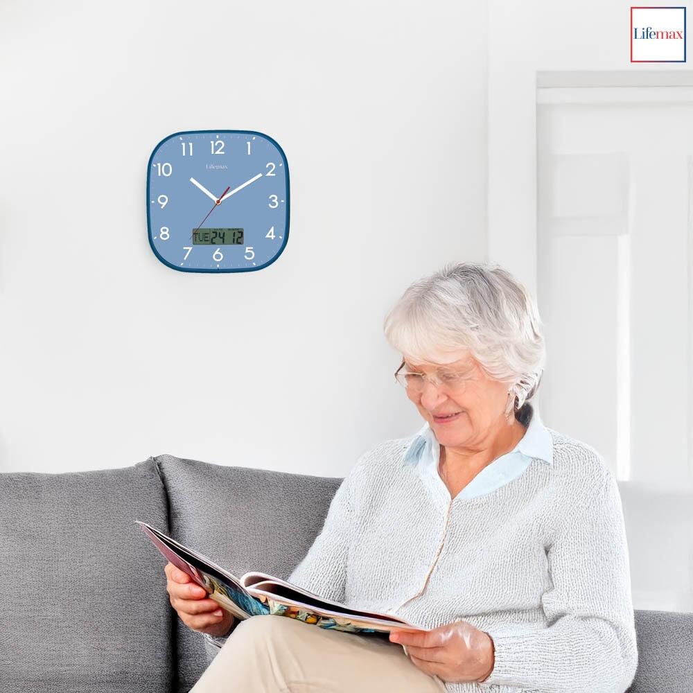 Lifemax Blue faced clear time day date clock hung in a living space