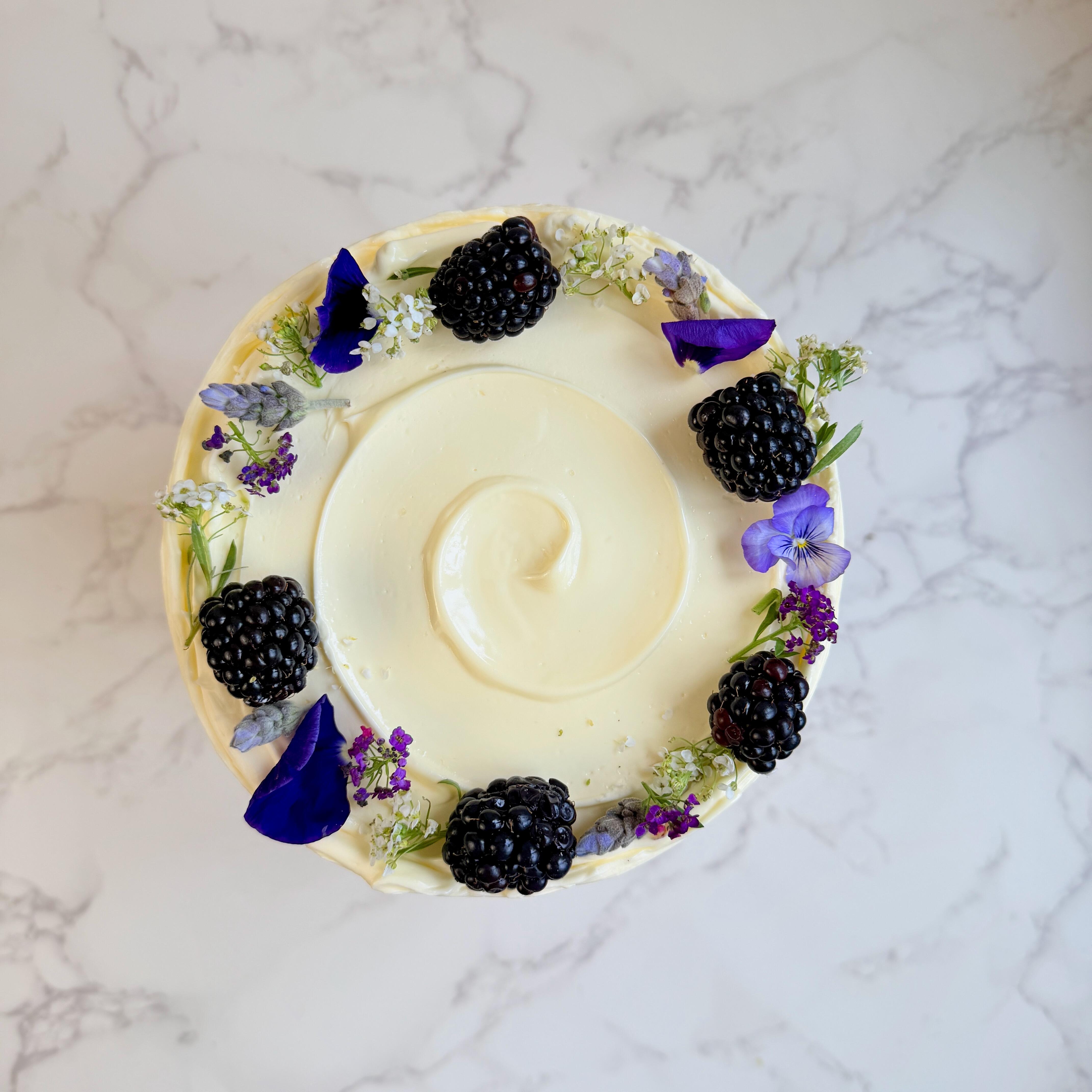 Blackberry cake decorated with fresh blackberries and flowers