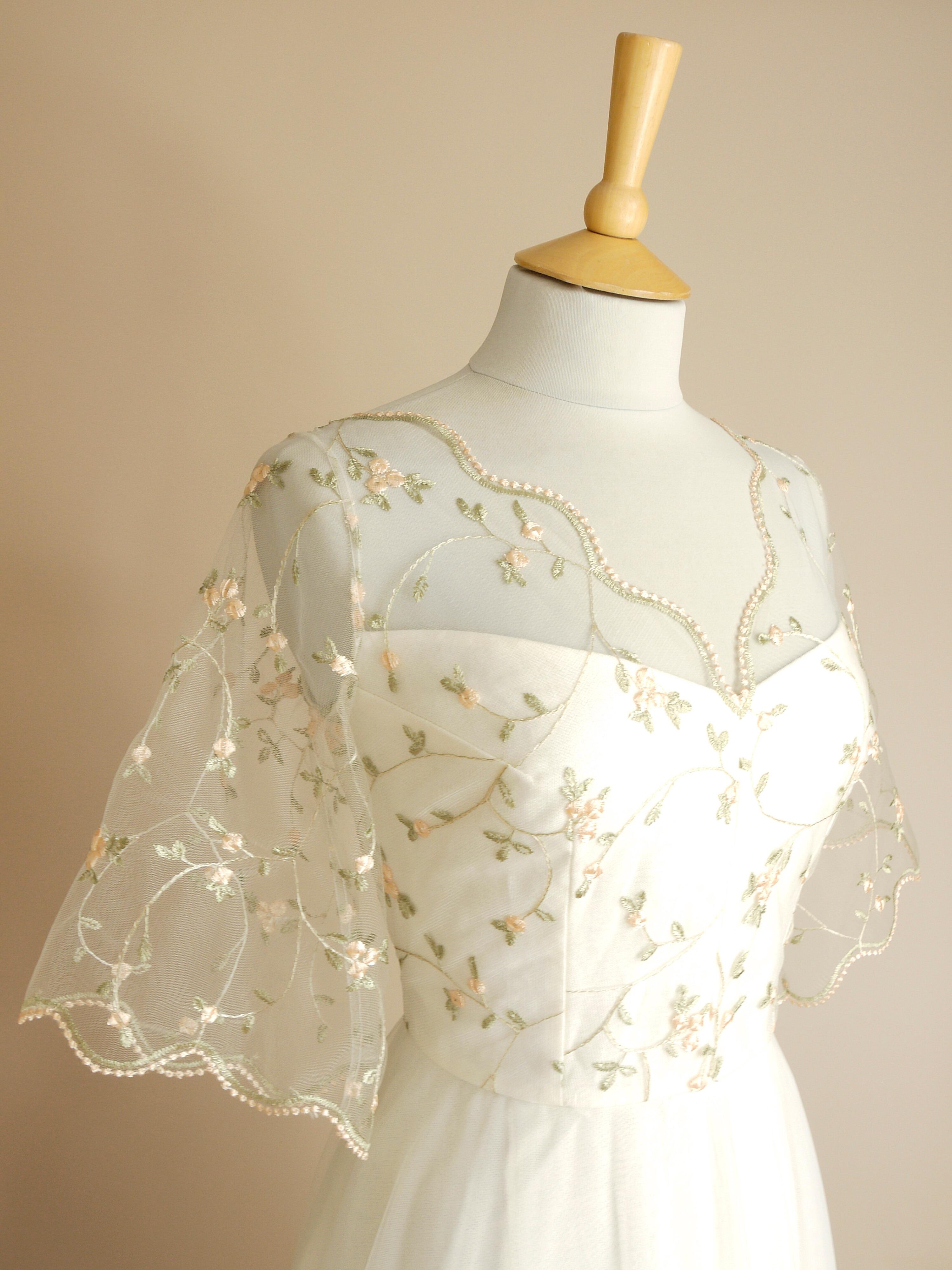 a close up of the fitted bodice with flared 3/4 length lace sleeves on the Blossom wedding dress