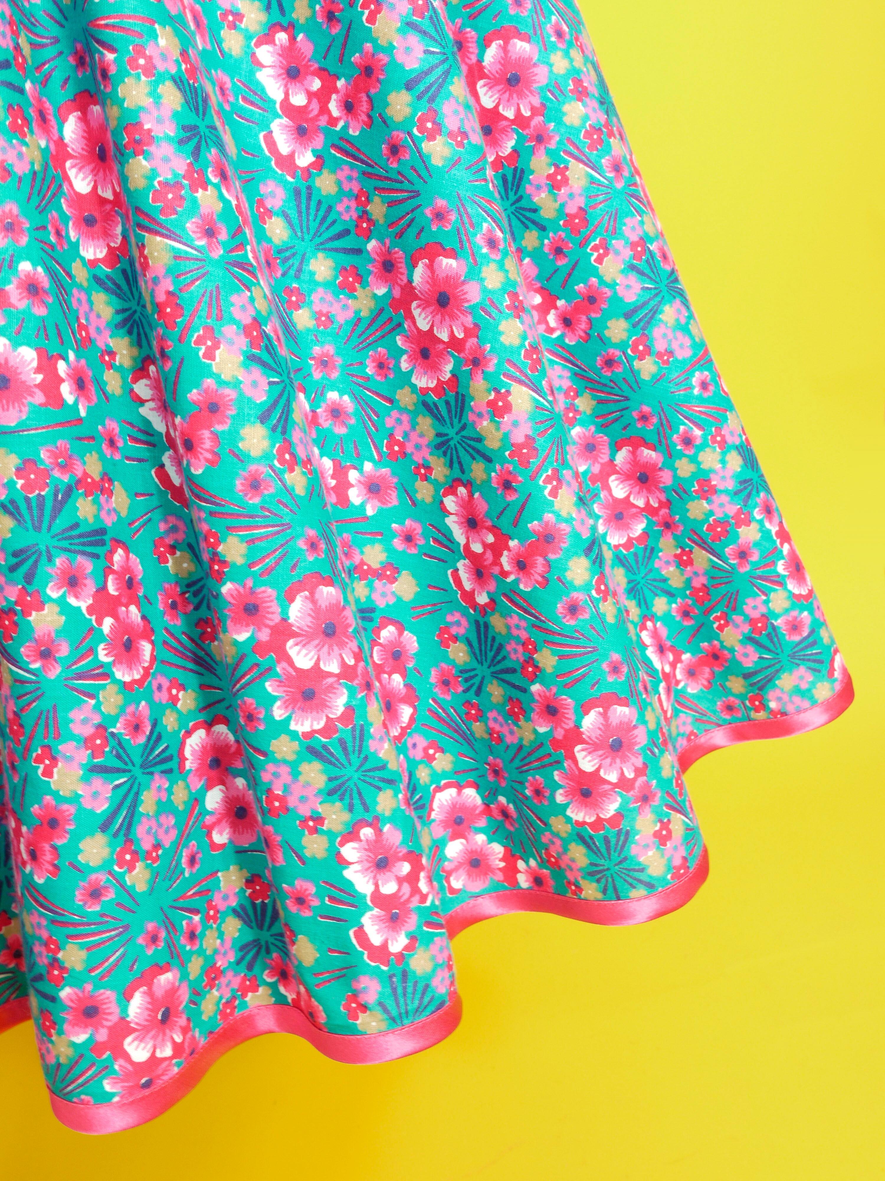A 1950s style dress made in turquoise and bright pink patterned cotton fabric