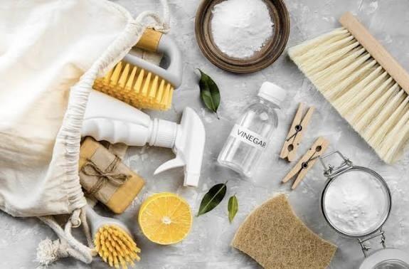 Various cleaning products arranged on a grey tablecloth