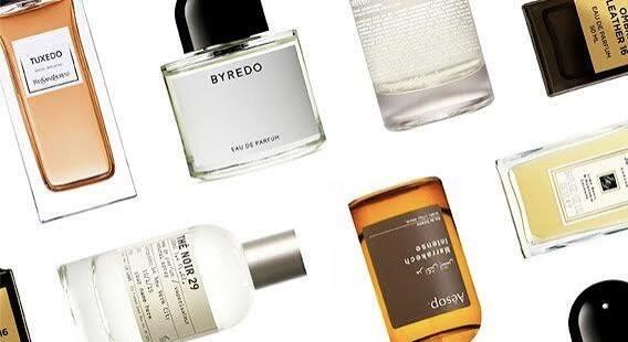 Various luxury fragrance bottles arranged on a white table, showcasing a curated collection of perfumes.
