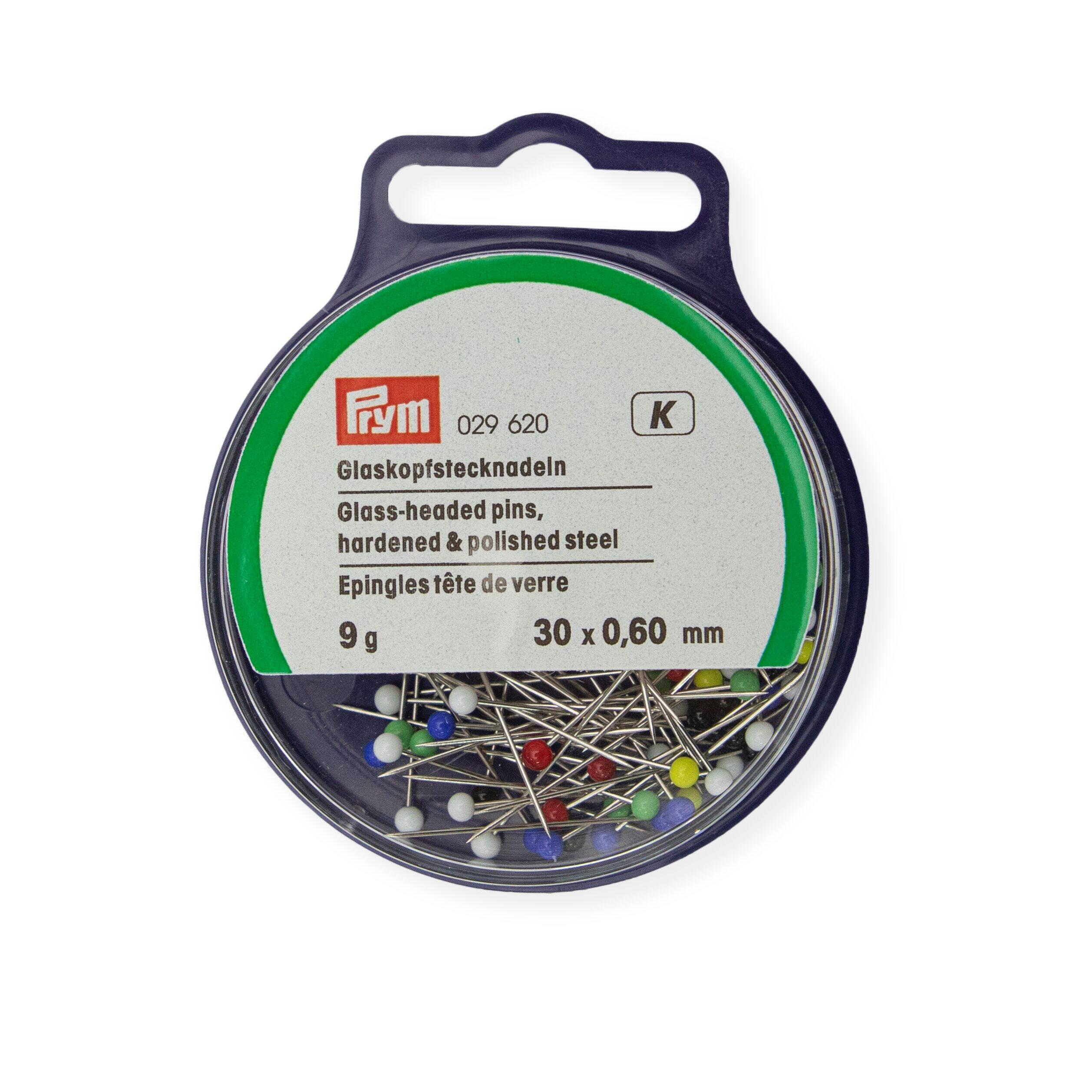 A circular plastic box containing 9g of 0.60mm x 30mm glass headed pins from Prym.