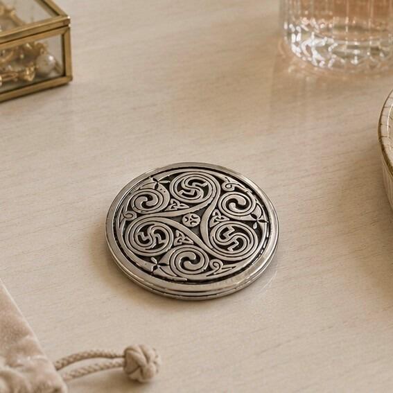 Round pewter compact purse mirror featuring an intricate traditional Celtic triskele design with three large interconnected spirals and small trinity knots