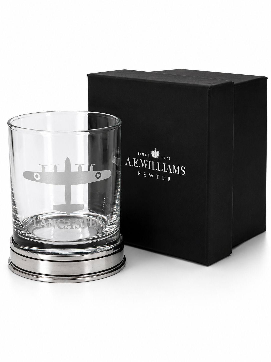 A whisky glass engraved with a lancaster bomber design next to a gift box
