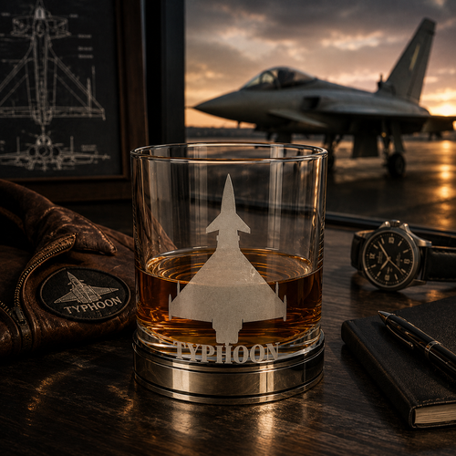 Handcrafted pewter Eurofighter Typhoon whisky tumbler filled with Scotch whisky on a polished pewter base, displayed in a luxury aviation lounge with a Typhoon fighter jet in the background, premium British made aviation whisky glass gift