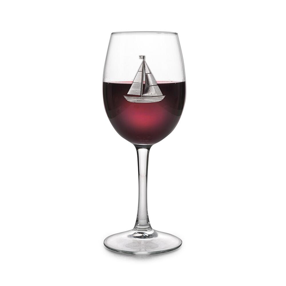 Wine glass with handmade pewter sailing yacht badge filled with red wine