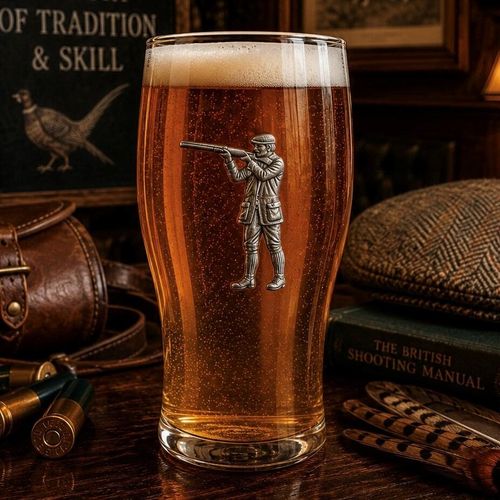 Pint glass with handmade pewter shooting scene with detailed shotgun and clay pigeon targets badge filled with golden beer