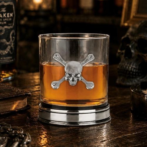 Whisky tumbler with pewter skull motif and polished base, partially filled with amber liquid
