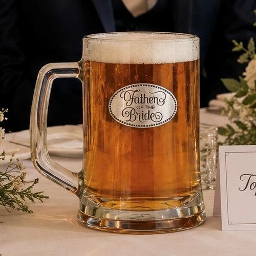 A Beer Tankard with a Pewter Father of the Bride badge on the front, filled with Amber Beer