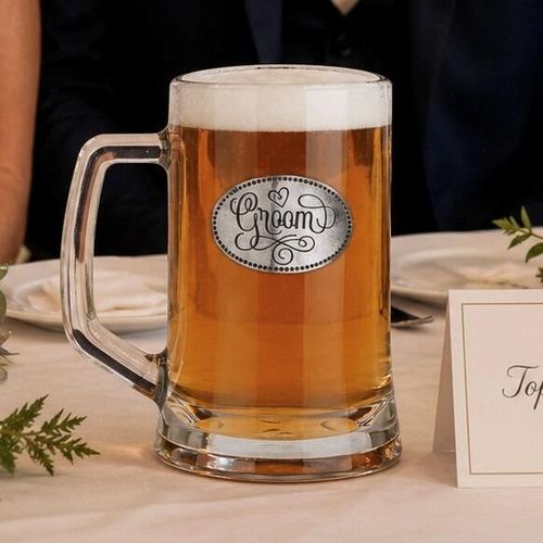 A Beer Tankard with a Pewter Groom badge on the front, filled with Amber Beer