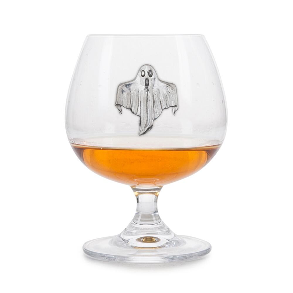 Crystal brandy glass with pewter ghost emblem, partially filled with amber liquid