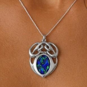 An Archibald Knox style pewter pendant featuring a polished Art Nouveau openwork top and a large oval central inlay of vibrant blue and green enamel