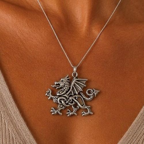 Detailed pewter Celtic Welsh dragon pendant featuring intricate knotwork on the body, textured wings, and a spade tail