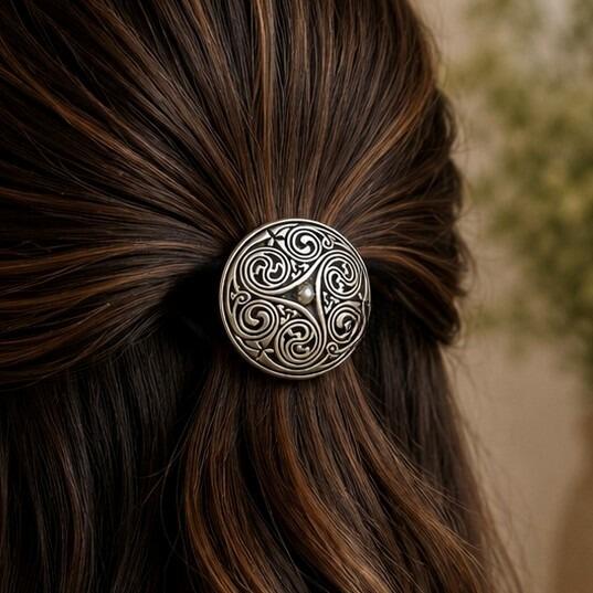 Round dome-style pewter Celtic hair bobble featuring three large interlocking triskele spirals and a small central bead accent